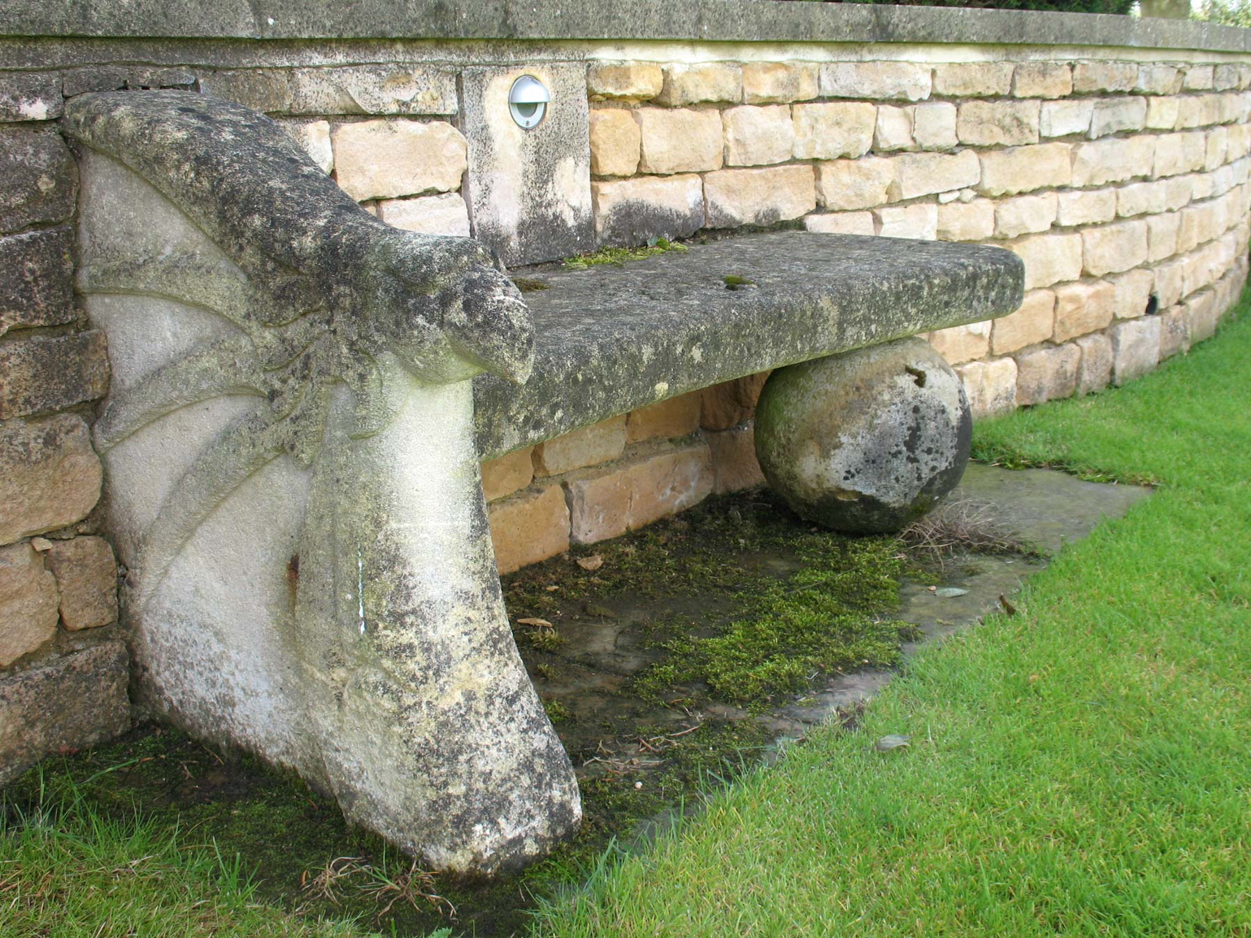 Stylised bath stone dragon wing seats in the garden of a country lodge in Leicestershire designed by Peter Eustance
