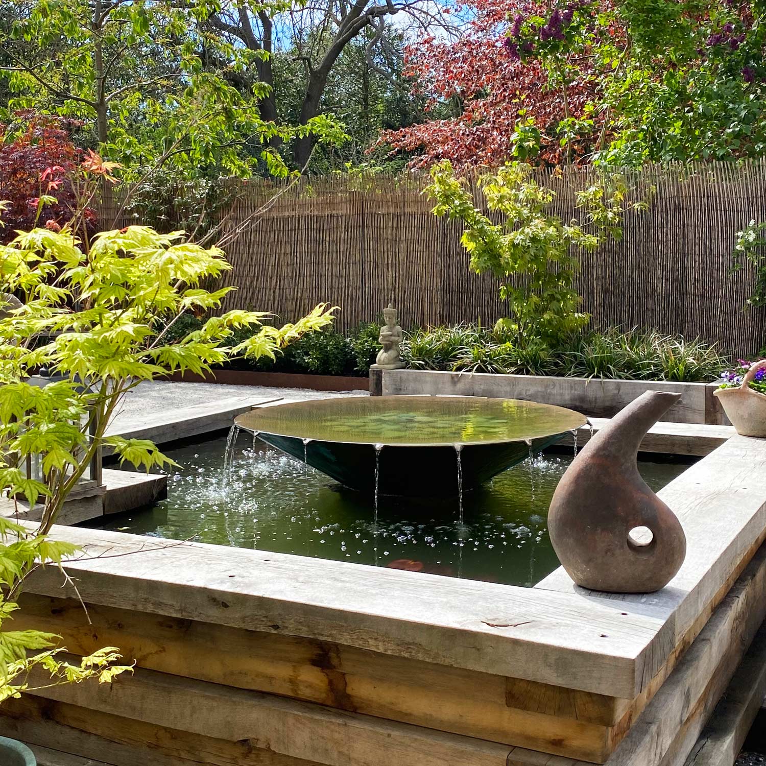 Windsor 4 Raised pond with layered oak walls and Trasimeno saucer water feature designed by Peter Eustance